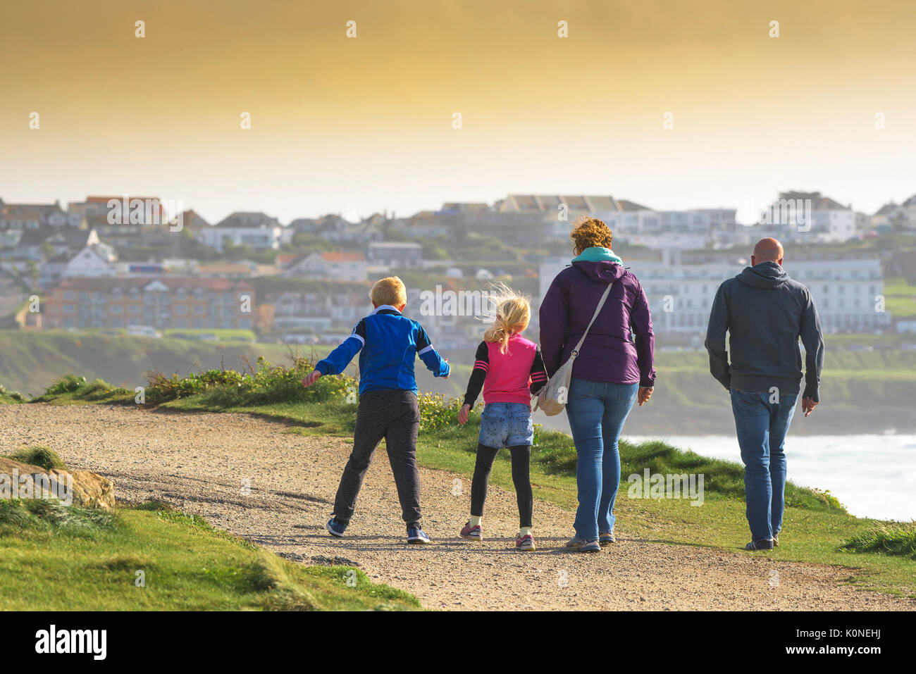 Una famiglia di vacanzieri godendo di una tonificante passeggiata in condizione di vento. Foto Stock