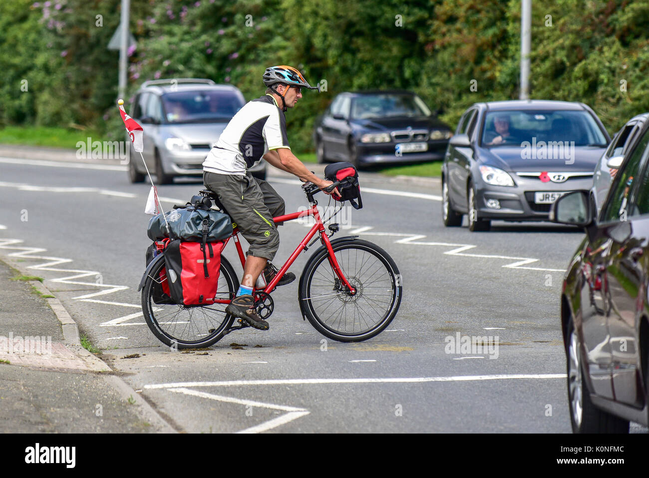 Un ciclista attraversare una strada a Newquay in Cornovaglia. Foto Stock