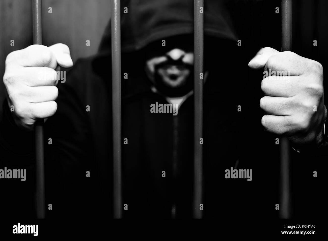 Abstract. Le mani del prigioniero su un traliccio di acciaio vicino. Il carcere, uomo in manette. Foto Stock