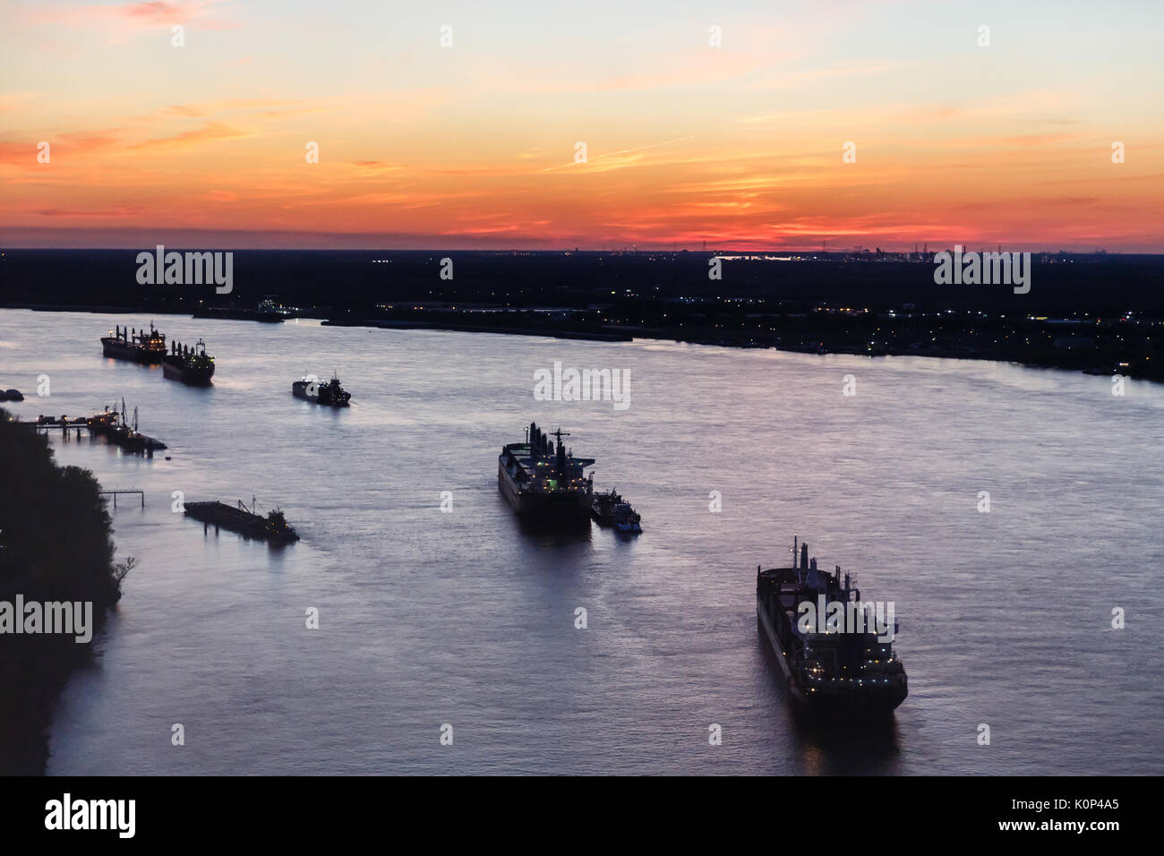 Petroliera navi formano una linea lungo il fiume Mississippi al tramonto Foto Stock