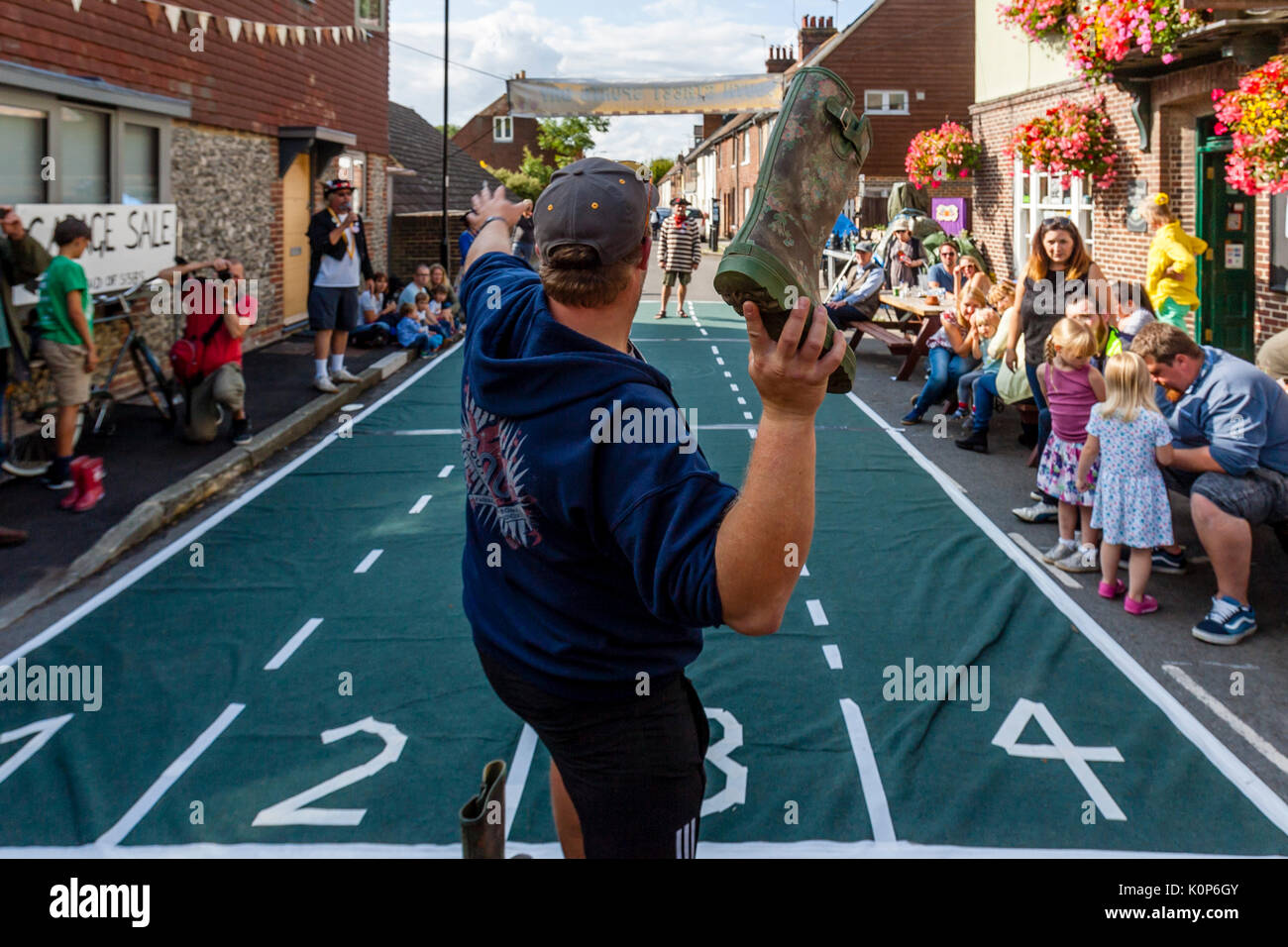 La popolazione locale prendere parte in un 'Welly gettando' concorrenza all'annuale South Street la giornata dello sport e Dog Show, Lewes, East Sussex, Regno Unito Foto Stock