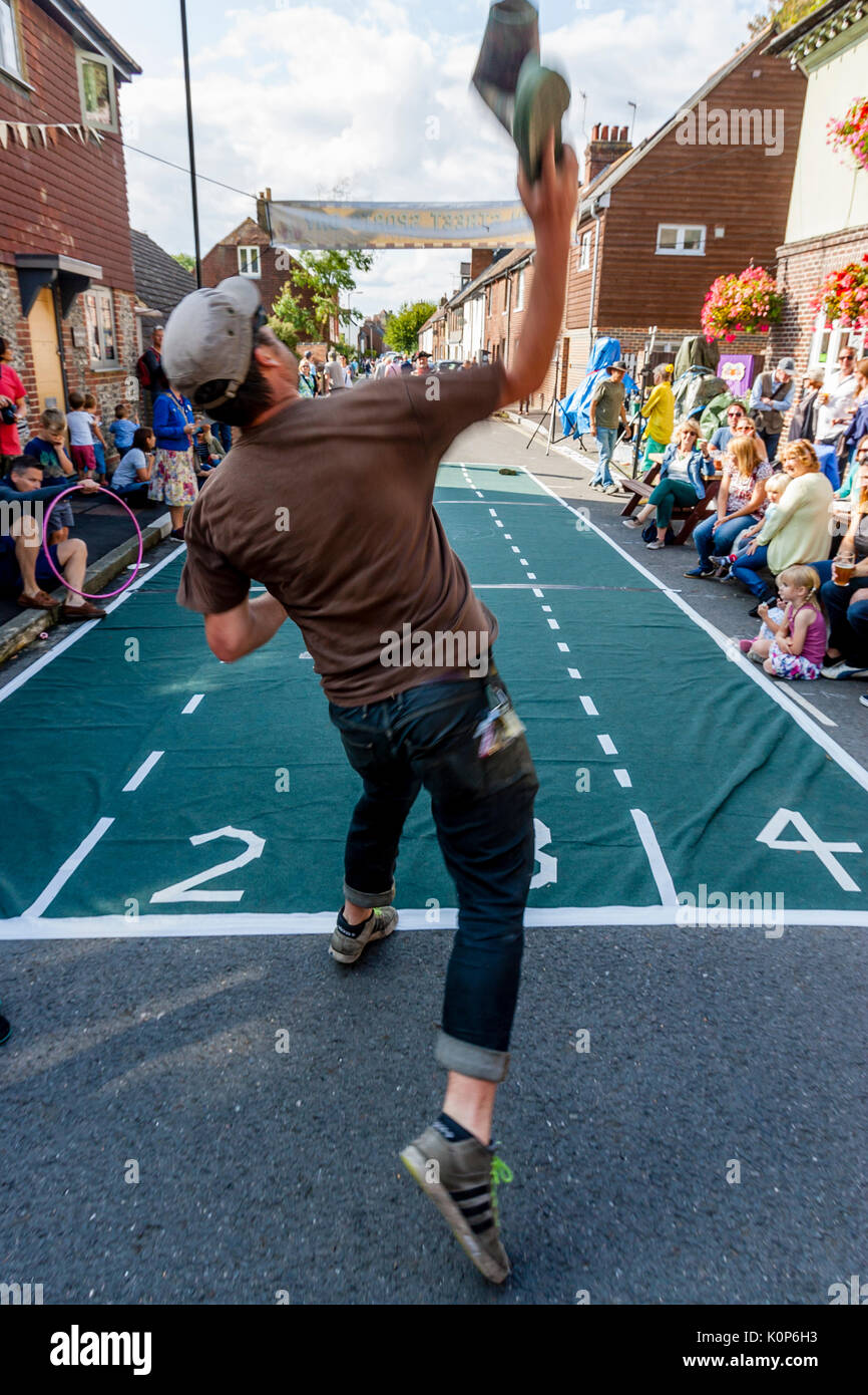 La popolazione locale prendere parte in un 'Welly gettando' concorrenza all'annuale South Street la giornata dello sport e Dog Show, Lewes, East Sussex, Regno Unito Foto Stock