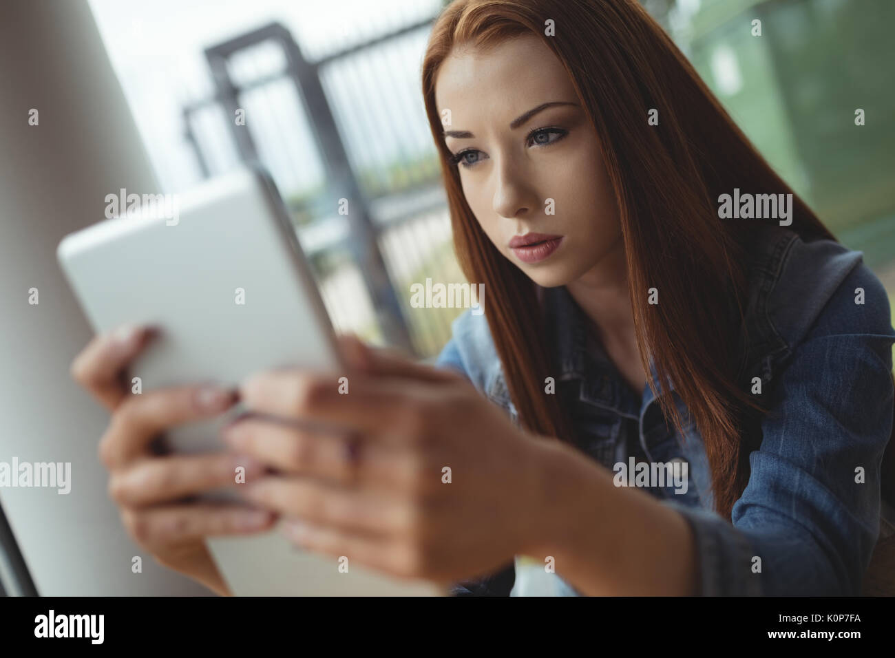 Close up della giovane donna con tavoletta digitale mentre è seduto in cafe Foto Stock