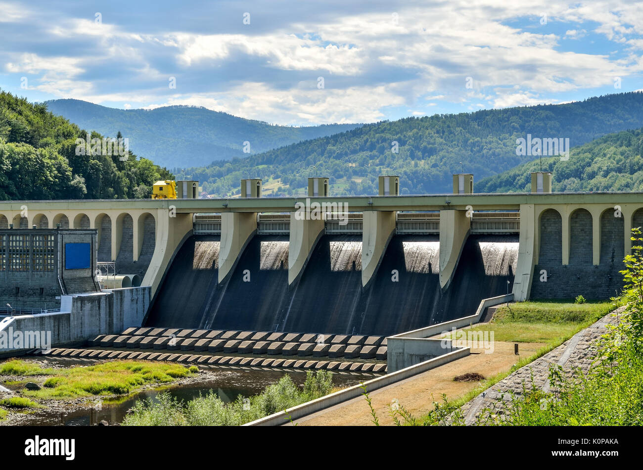 Estate paesaggio industriale. Serbatoio di acqua contro lo sfondo delle montagne. Foto Stock