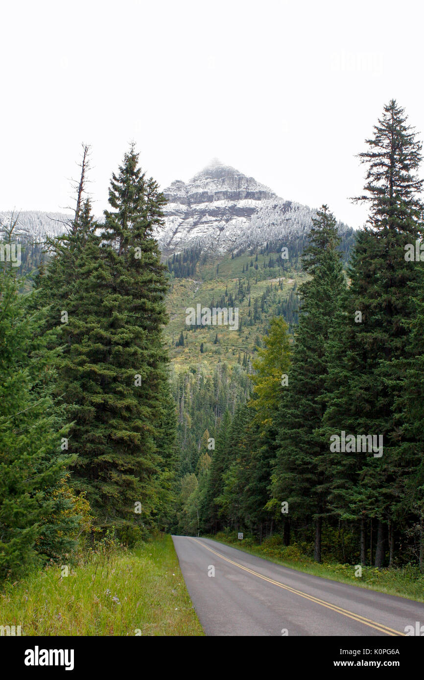 Vista della Montagna innevata con picco di nebbia lungo la strada di Sun - Parco nazionale di Glacier, MONTANA Foto Stock