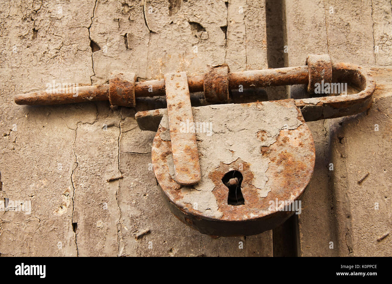 Il vecchio bullone arrugginito e un lucchetto sulla porta di legno Foto Stock