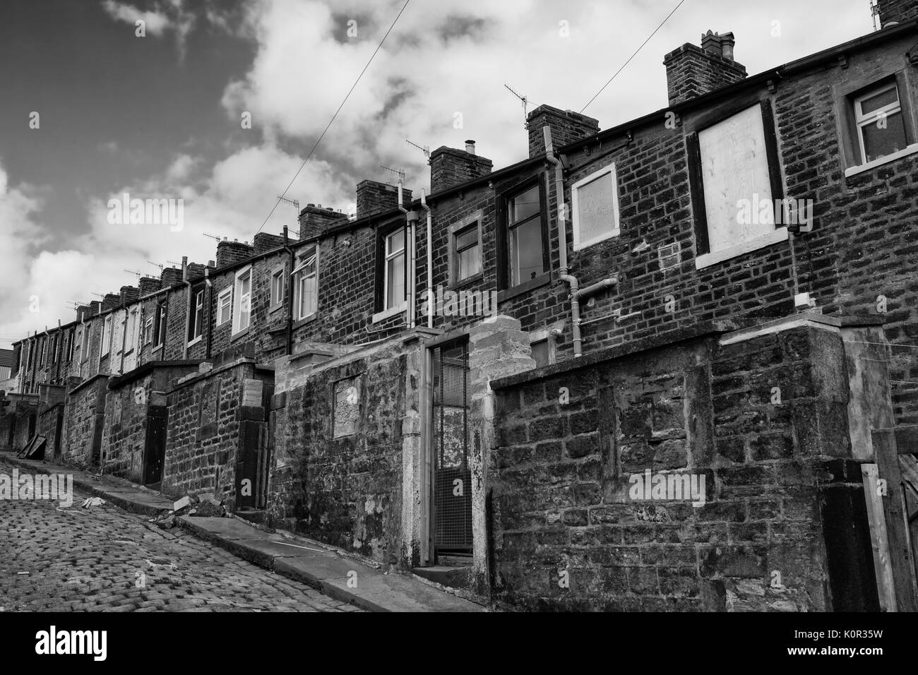 Millworkers' cottages sul retro corsia tra Basil Street e Walton Street, Colne Lancashire, Inghilterra, Regno Unito: versione in bianco e nero Foto Stock