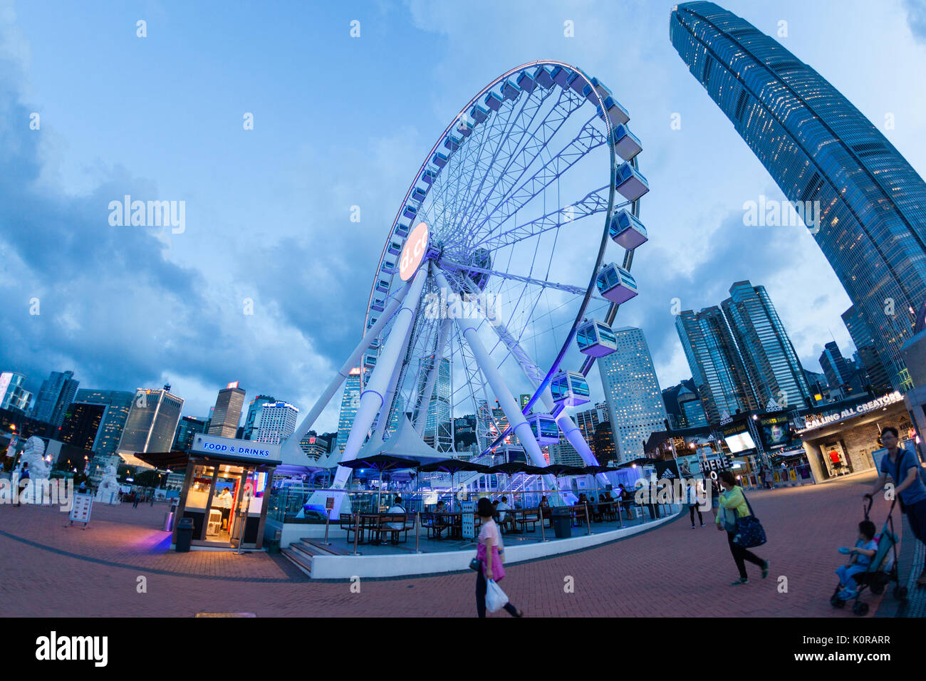 HONG KONG, luglio 10, 2017: Ampia angolazione della ruota di osservazione a Hong Kong il molo centrale nei pressi del porto di Victoria durante il tramonto con il centro cittadino di f Foto Stock