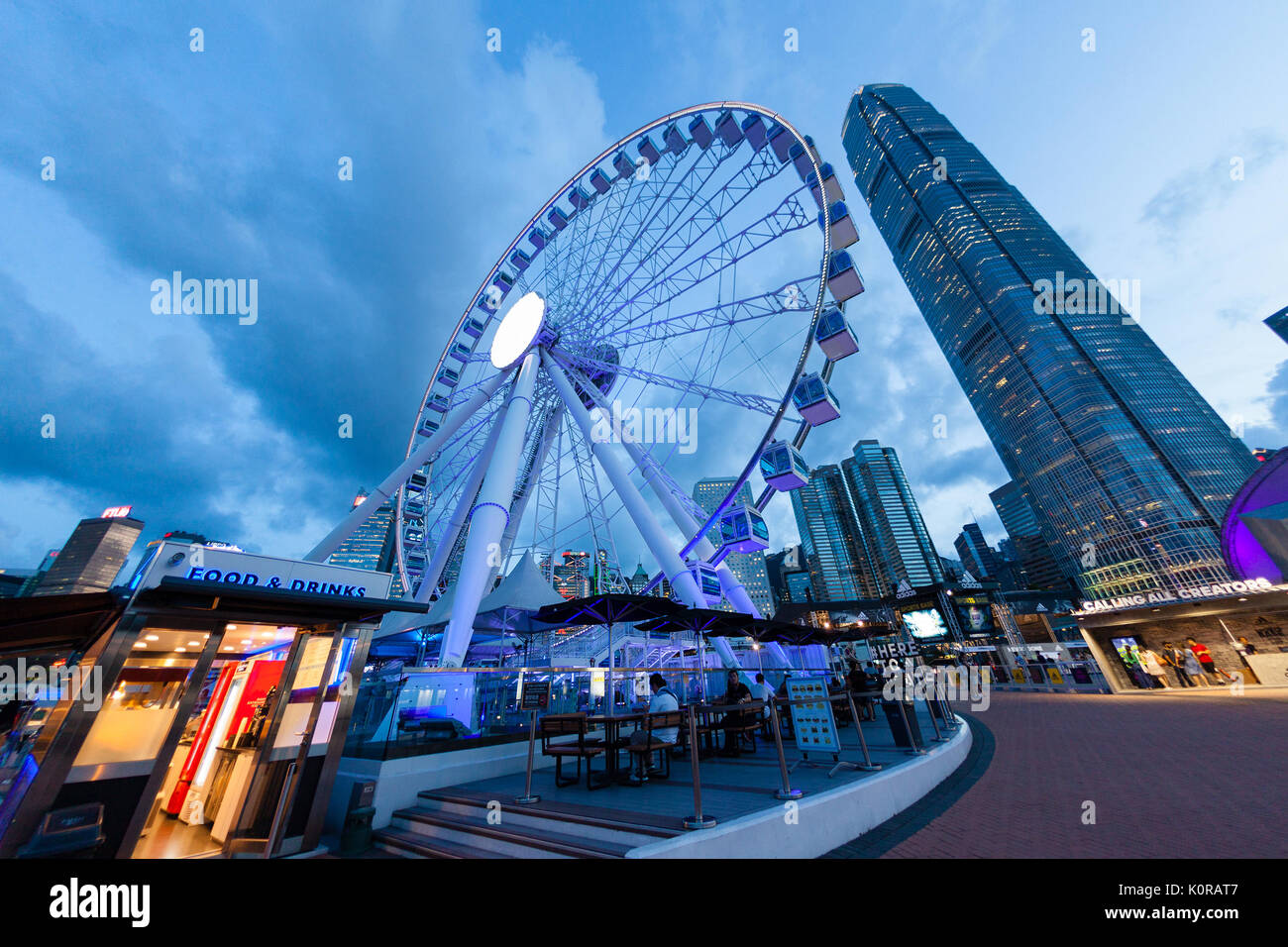HONG KONG, luglio 10, 2017: Ampia angolazione della ruota di osservazione a Hong Kong il molo centrale nei pressi del porto di Victoria durante il tramonto con il centro cittadino di f Foto Stock
