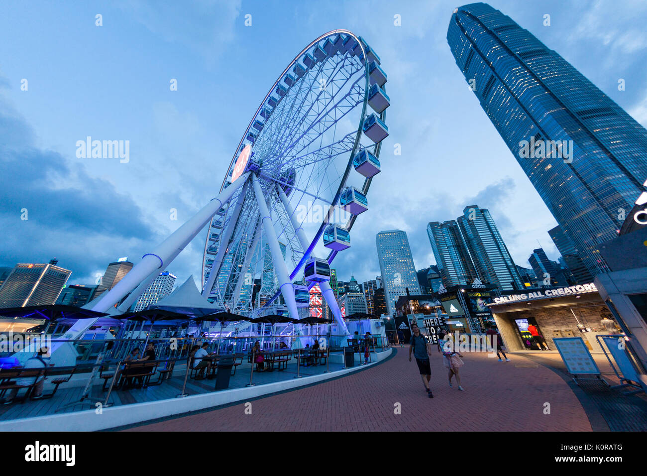 HONG KONG, luglio 10, 2017: Ampia angolazione della ruota di osservazione a Hong Kong il molo centrale nei pressi del porto di Victoria durante il tramonto con il centro cittadino di f Foto Stock