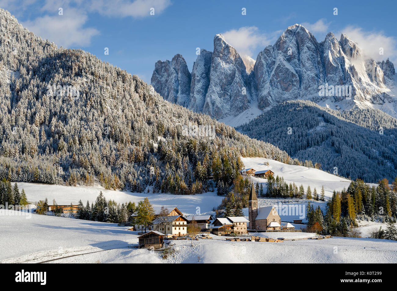 La chiesa nel villaggio Santa Maddalena o Santa Maddalena in Vileness o Val di Funes con Dolomiti sotto un manto di neve in inverno in Italia. Foto Stock