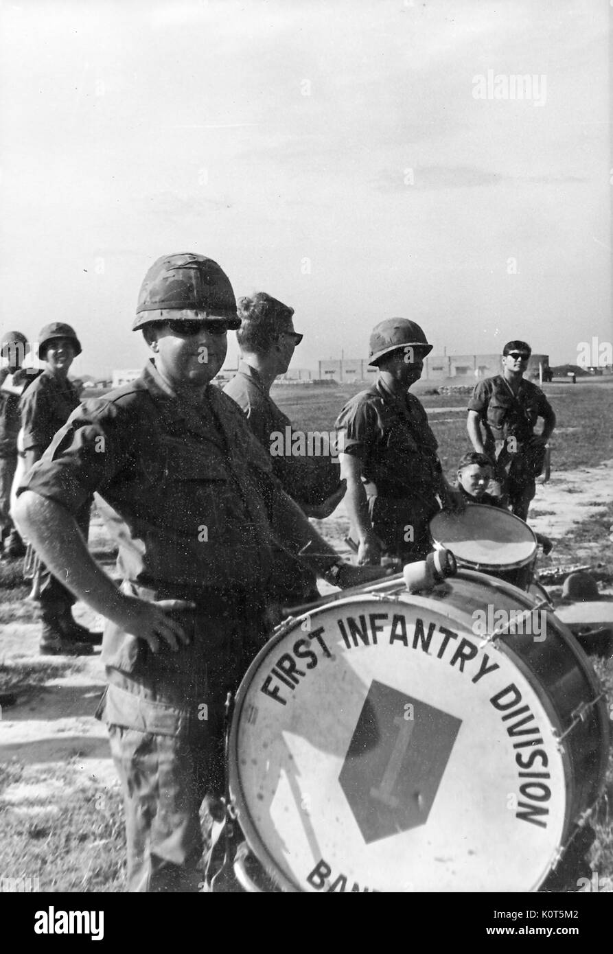 Una fotografia dei membri dell'esercito degli Stati Uniti Prima Divisione di Fanteria Band in posa con i loro strumenti in un aperto erba ed immondizia campo, Vietnam, 1967. Foto Stock