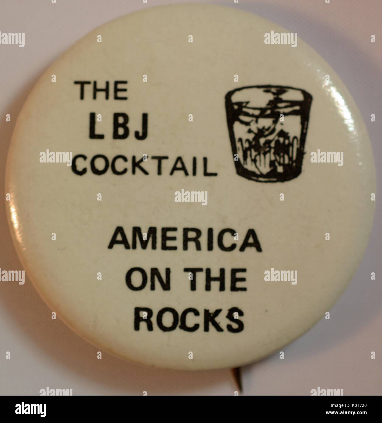 Un perno di politico che è costituito da un fondo bianco con un nero illustrazione di un bicchiere tumbler con ghiaccio in esso, caratteristiche il testo "LBJ cocktail' e 'America sulle rocce", è stato creato per manifestare la propria opposizione alla allora presidente Lyndon B Johnson cerca di rielezione, 1970. Foto Stock