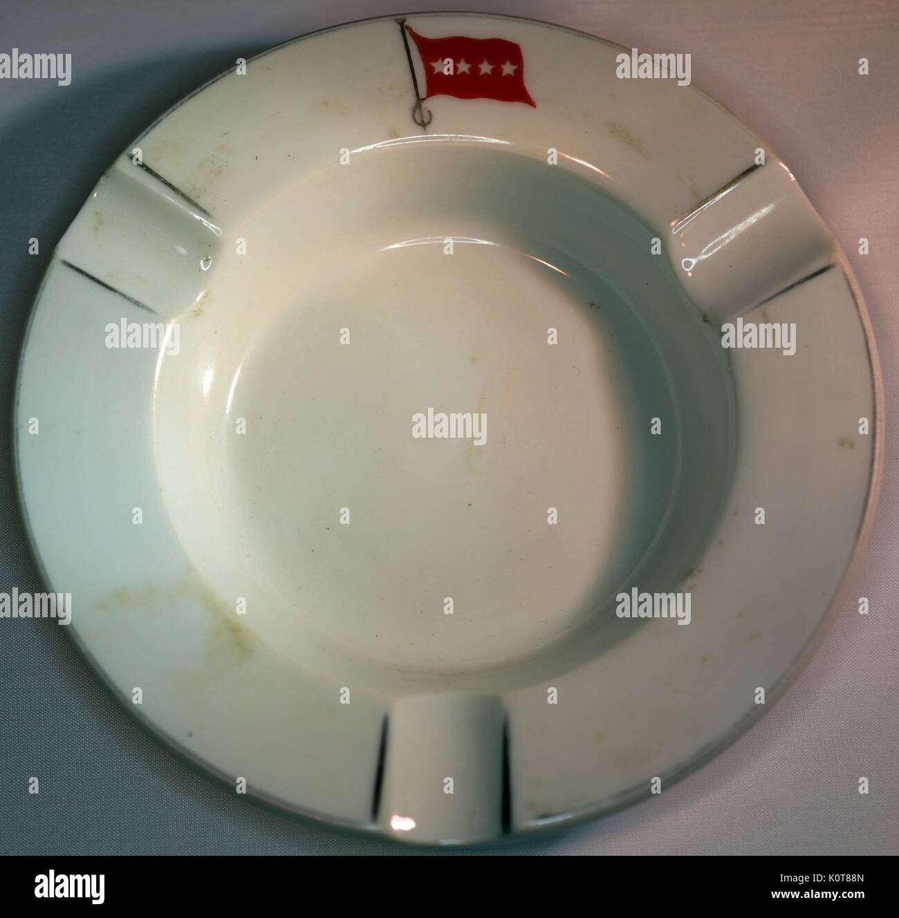 Una fotografia di un colore bianco porcellana posacenere che dispone di una piccola bandiera rossa contenente quattro stelle bianche, 1968. Foto Stock