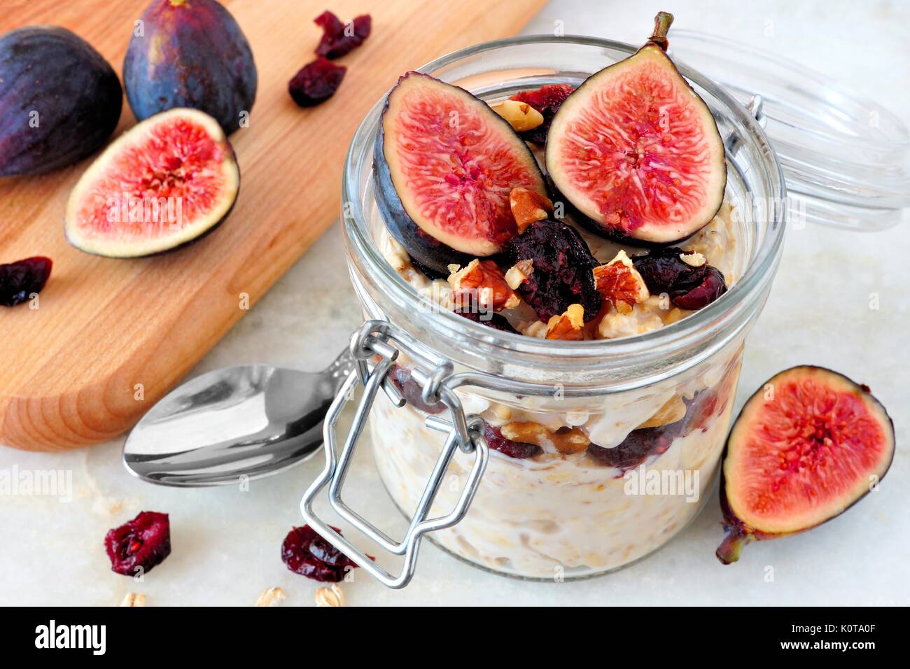 Vaso di notte autunno avena con red fichi, mirtilli e noci contro un sfondo marmo Foto Stock