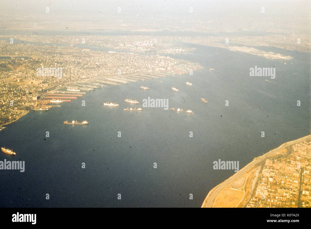 Vista aerea rivolto a nord-ovest di la marea si restringe stretto tra la parte superiore e inferiore di alloggiamenti per il porto di New York, New York City, 1957. in background attraverso il bordo superiore del telaio è il new jersey costa e il porto di Newark. attraverso newark bay è bayonne, new jersey, in cui i militari ocean terminal è situato sul lato est. appena a sud è il Connestabile area gancio sul kill van kull fluviale, che separa la terraferma da North Shore di staten island. Al centro, da sinistra a destra lungo la riva del fiume sono i quartieri di Rosebank, stapleton, tompkinsville e st. ge Foto Stock