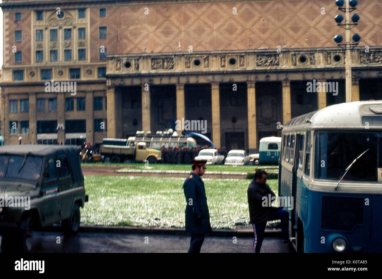 Scena di strada a Mosca, Russia sovietica, URSS, di un ufficiale di polizia di stato che ispeziona un tour bus con l'autista, novembre 1973. Sullo sfondo, le auto e gli autobus sono parcheggiati sulla strada quando i passeggeri sbarcano. Foto Stock