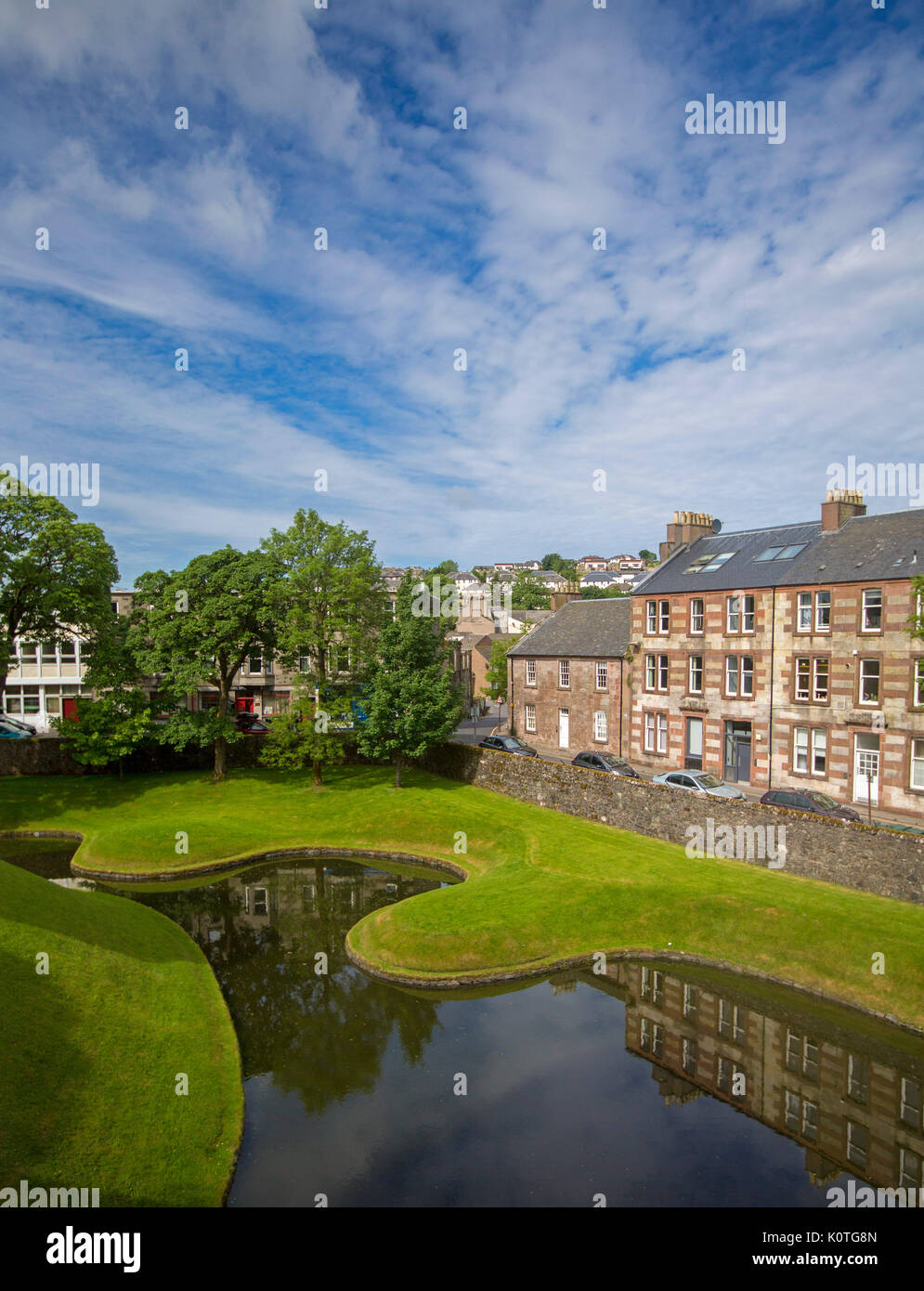 Vista dal castello storico, della città di Rothesay con edifici riflettono in acqua del fossato sotto il cielo blu sull isola di Bute, Scozia Foto Stock