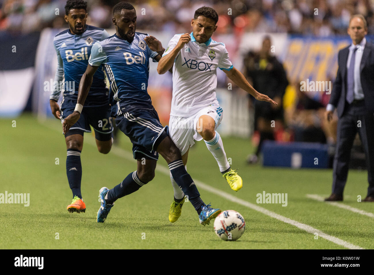 Vancouver, Canada. 23 Ago, 2017. Tony Tchani (16) di Vancouver Whitecaps impegnativo Cristian Roldan (7) di Seattle sirene. Il gioco termina in una cravatta 1-1, con obiettivi da Nicolas Lodeiro (10) di Seattle, sirene e Fredy Montero (12) di Vancouver Whitecaps Vancouver Whitecaps vs Seattle sirene, BC Place Stadium. Credito: Gerry Rousseau/Alamy Live News Foto Stock