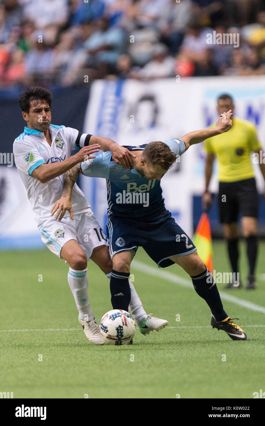 Vancouver, Canada. 23 Ago, 2017. Nicolas schedario Rolodex (10) di Seattle, sirene e Giordania Harvey (2) di Vancouver Whitecaps, in lotta per la sfera. Il gioco termina in una cravatta 1-1, con obiettivi da Nicolas Lodeiro (10) di Seattle, sirene e Giordania Harvey di Vancouver Whitecaps Vancouver Whitecaps vs Seattle sirene, BC Place Stadium. Credito: Gerry Rousseau/Alamy Live News Foto Stock