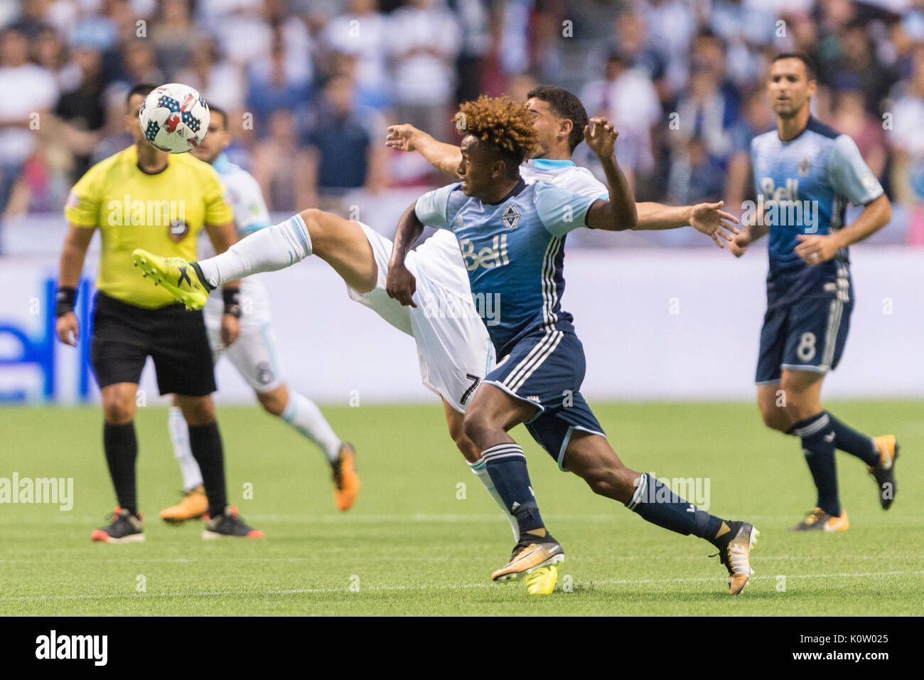 Vancouver, Canada. 23 Ago, 2017. Cristian Roldan (7) di Seattle sirene, raggiungendo a calciare la palla da Yordi Reyna (29) di Vancouver Whitecaps. Il gioco termina in una cravatta 1-1, con obiettivi da Nicolas Lodeiro (10) di Seattle, sirene e Fredy Montero (12) di Vancouver Whitecaps Vancouver Whitecaps vs Seattle sirene, BC Place Stadium. Credito: Gerry Rousseau/Alamy Live News Foto Stock