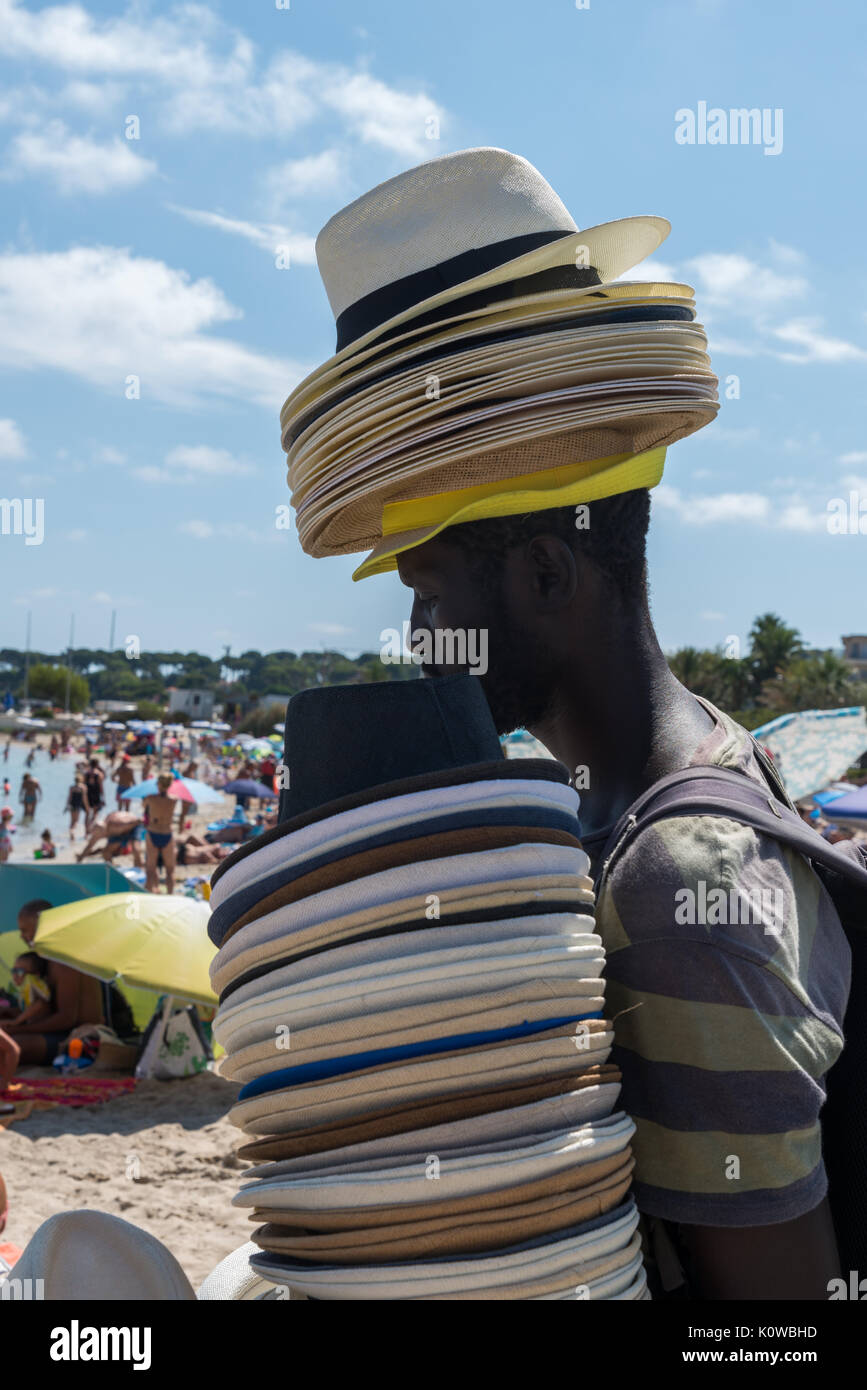 Un uomo africano vende cappelli di paglia sulla spiaggia a Antibes, Francia  Foto stock - Alamy
