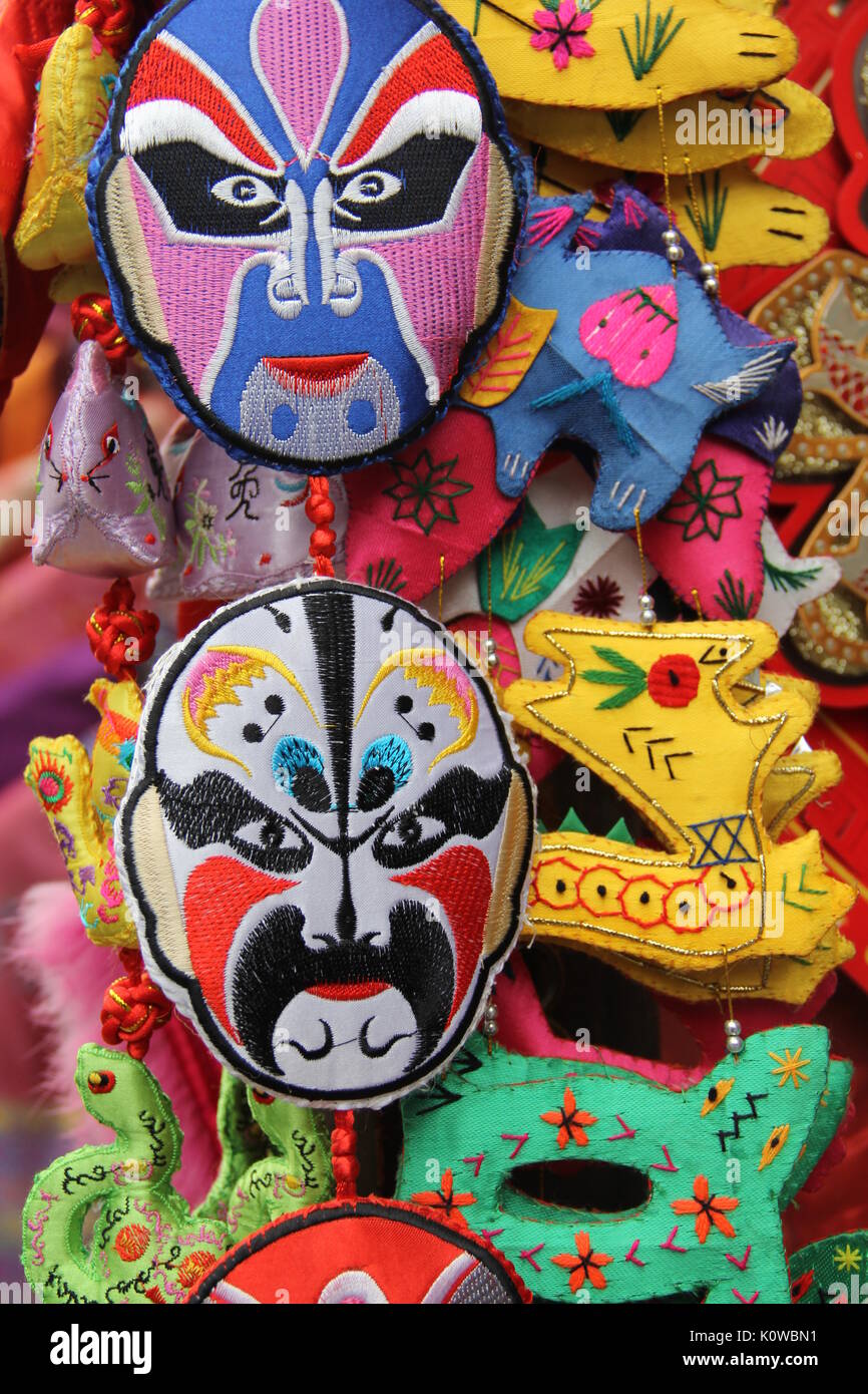 Cucito a mano colorata maschera cinesi in vendita venditore ambulante per turisti in Cina Foto Stock