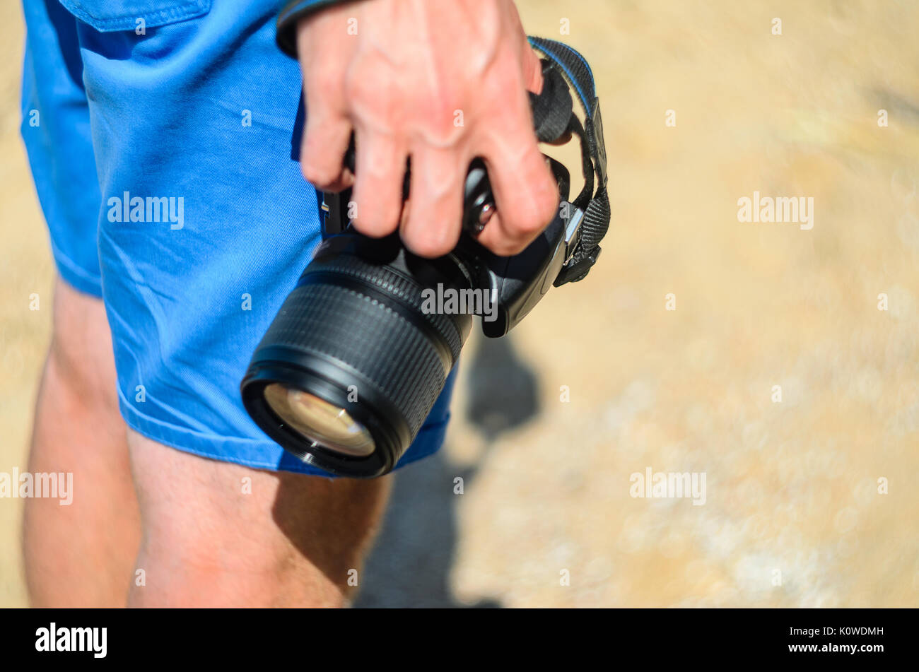 Fotocamera reflex digitale nelle mani di un fotografo su di una spiaggia di sabbia vicino fino Foto Stock