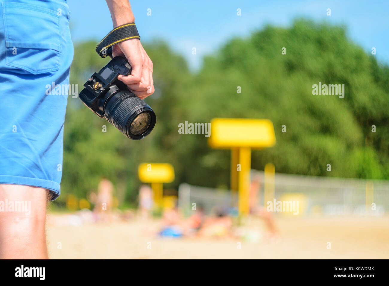 Fotocamera reflex digitale nelle mani di un fotografo su di una spiaggia di sabbia vicino fino Foto Stock