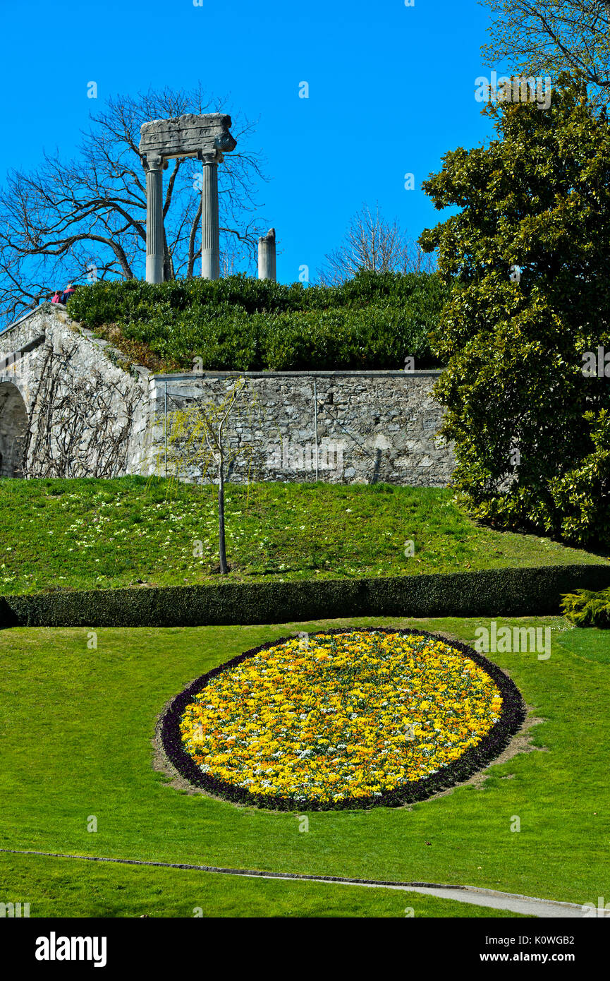 Medaglione di fiori di primavera nel parco, colonne romane dietro, Nyon, Canton Vaud, Svizzera Foto Stock