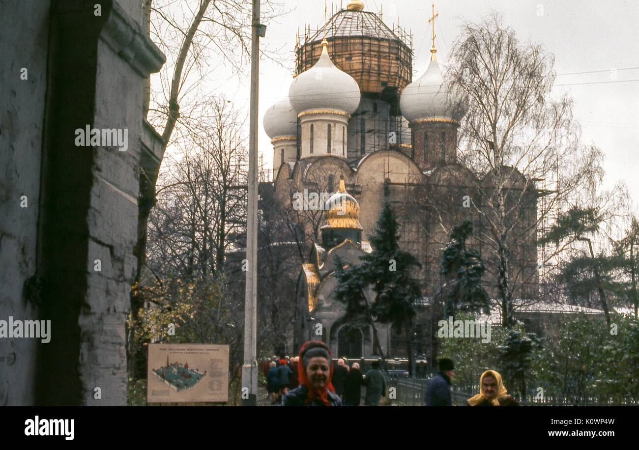 Vista dei visitatori fuori dalla Cattedrale di nostra Signora di Smolensk, presso il convento Novodevichy situato a Mosca, Russia sovietica, URSS, novembre 1973. La chiesa è in fase di riparazione, con ponteggi che coprono le pareti esterne e cupola centrale in oro cipolla. Foto Stock