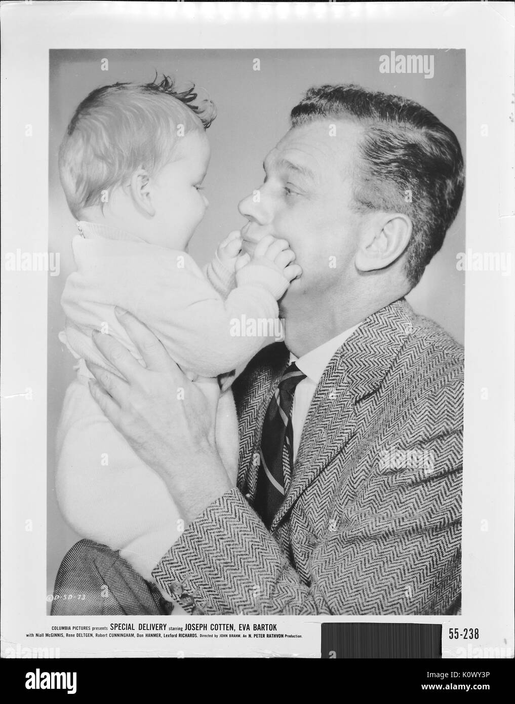Un film scena ancora da 'Speciale consegna" (1955 commedia film), che mostra un uomo adulto il sollevamento di un bambino con le sue due mani fino al suo livello di viso mentre il bambino goffamente pizzichi l'uomo di guance con le sue due mani, 1951. Foto Stock