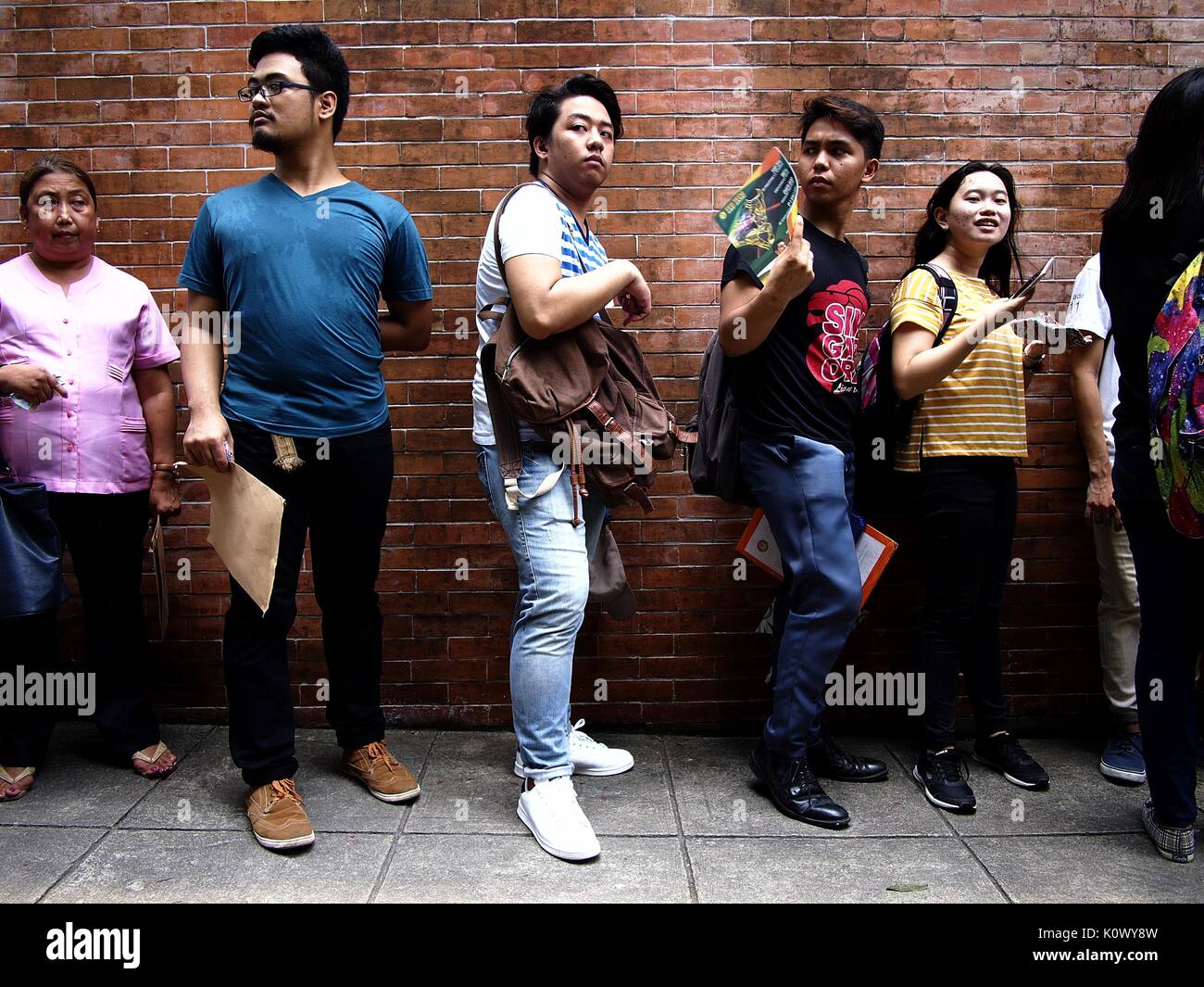 QUEZON CITY, Filippine - Agosto 16, 2017: Gli Studenti la linea fino a presentare il loro modulo di domanda per il collegio ingresso esame chiamato UPCAT dello stato Foto Stock