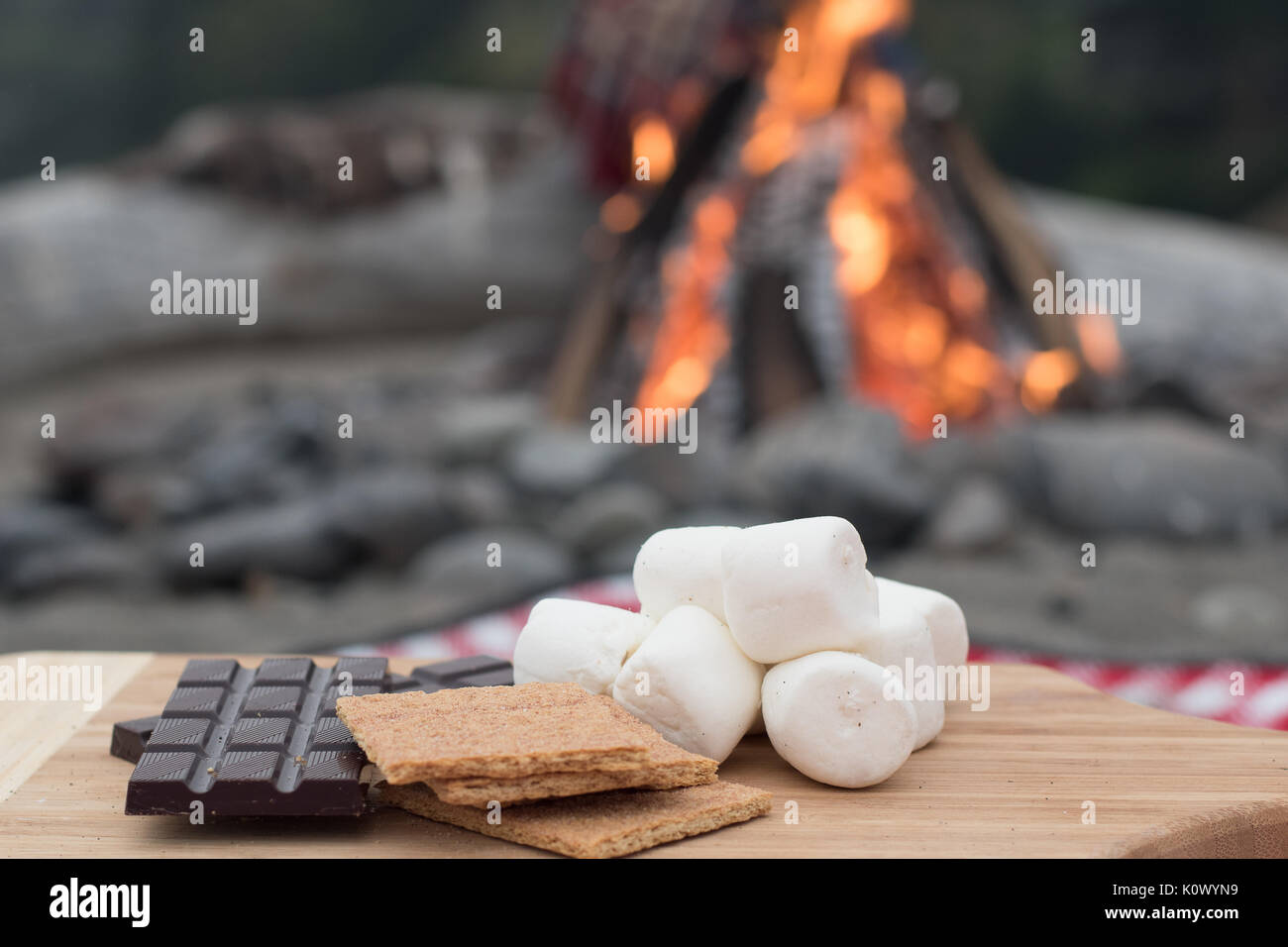 Smores ingredienti a un falò sulla spiaggia con cioccolato, Marshmallow, e Graham crackers con spazio per la copia Foto Stock