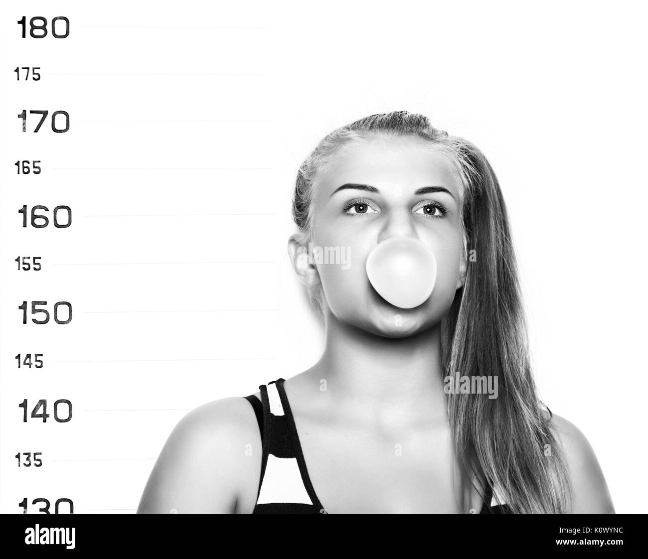 Giovane bella donna bionda chewing gum e soffiare bolle criminale mug shots Foto Stock
