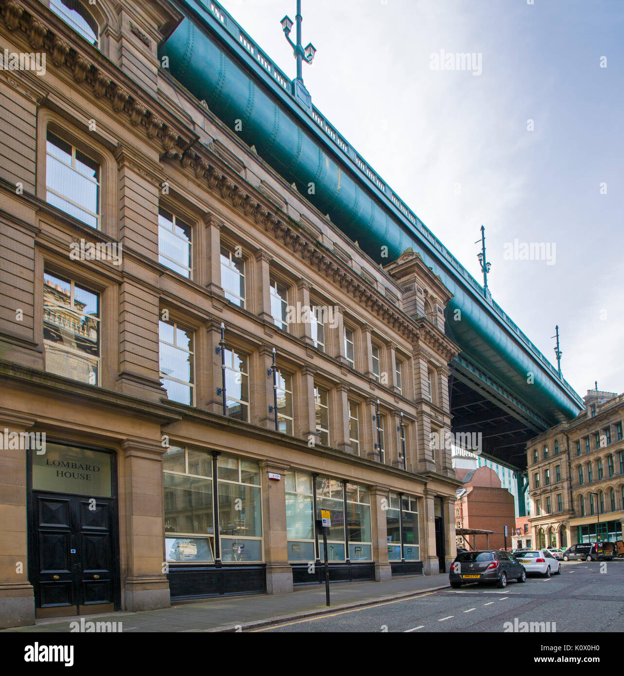 La sezione del Fiume Tyne Bridge tra sommità di edifici della città e la strada sotto il cielo blu a Newcastle-upon-Tyne, Inghilterra Foto Stock