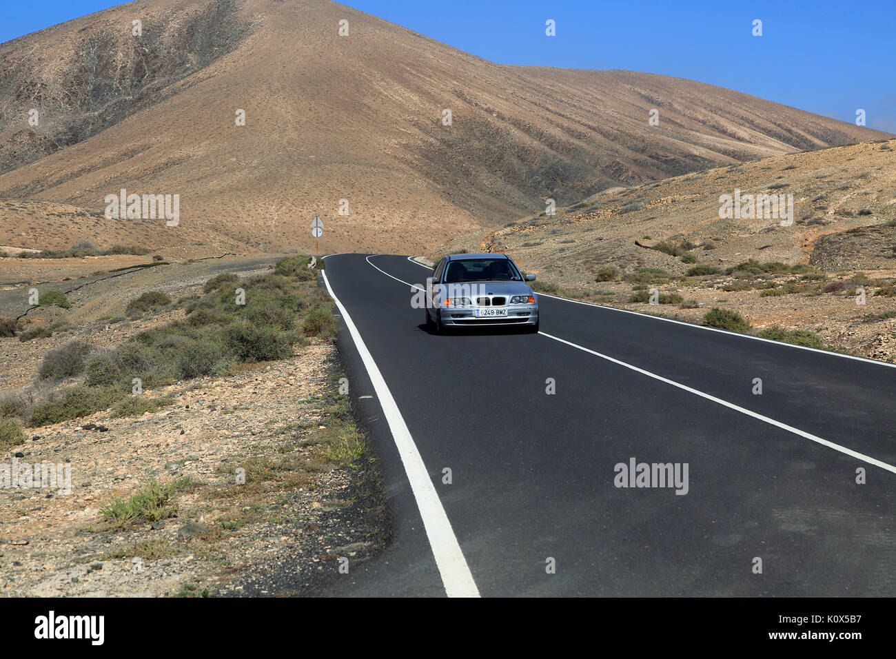 Su strada asfaltata attraversando il deserto, Fuerteventura, vicino a Pajara, Isole Canarie, Spagna Foto Stock