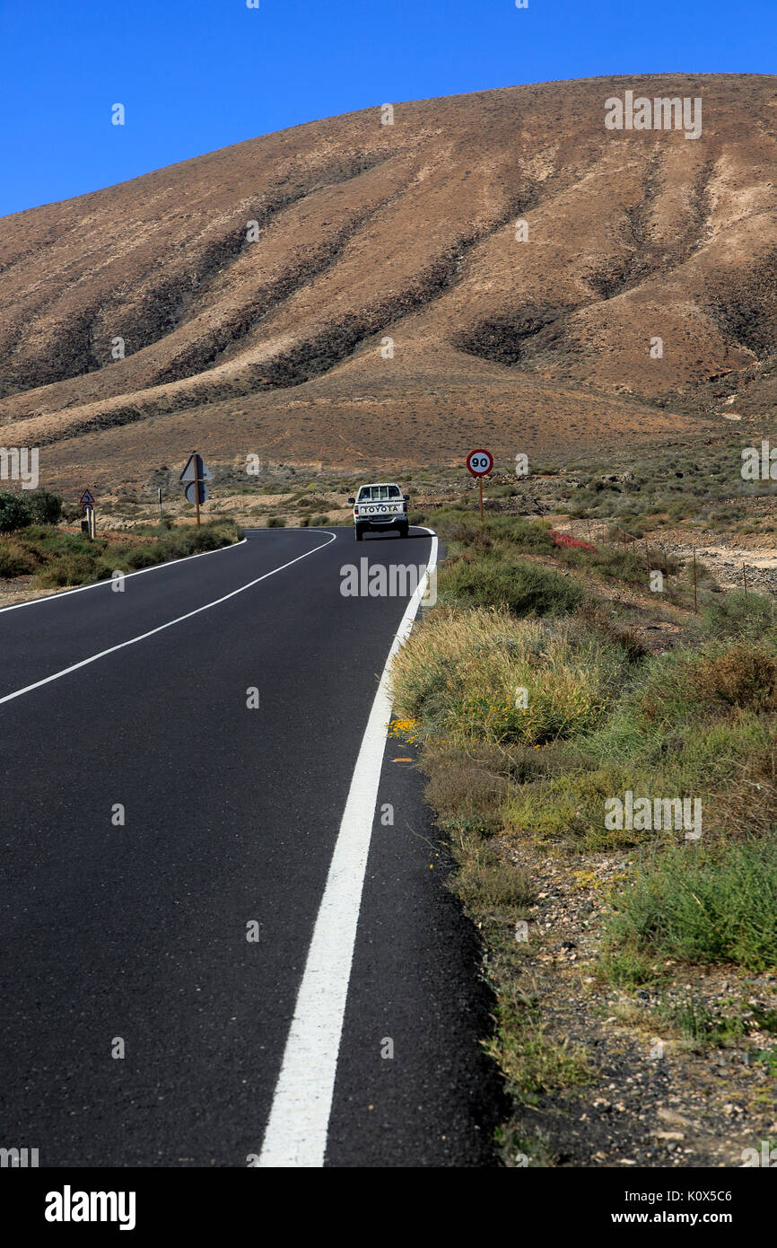 Su strada asfaltata attraversando il deserto, Fuerteventura, vicino a Pajara, Isole Canarie, Spagna Foto Stock