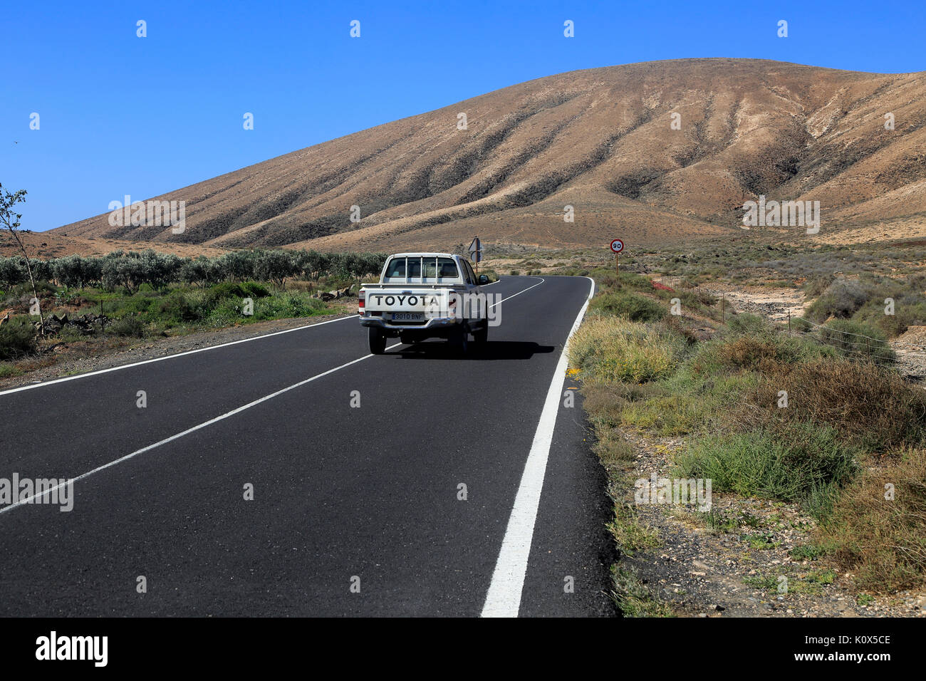 Su strada asfaltata attraversando il deserto, Fuerteventura, vicino a Pajara, Isole Canarie, Spagna Foto Stock