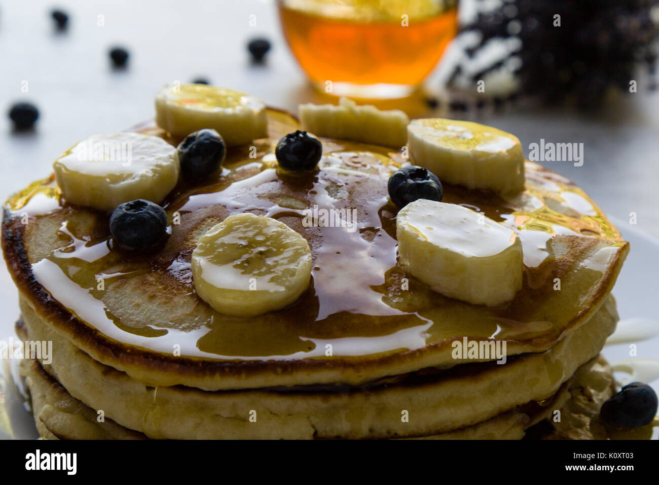 Frittelle di banane, mirtillo e miele nella luce del mattino Foto Stock