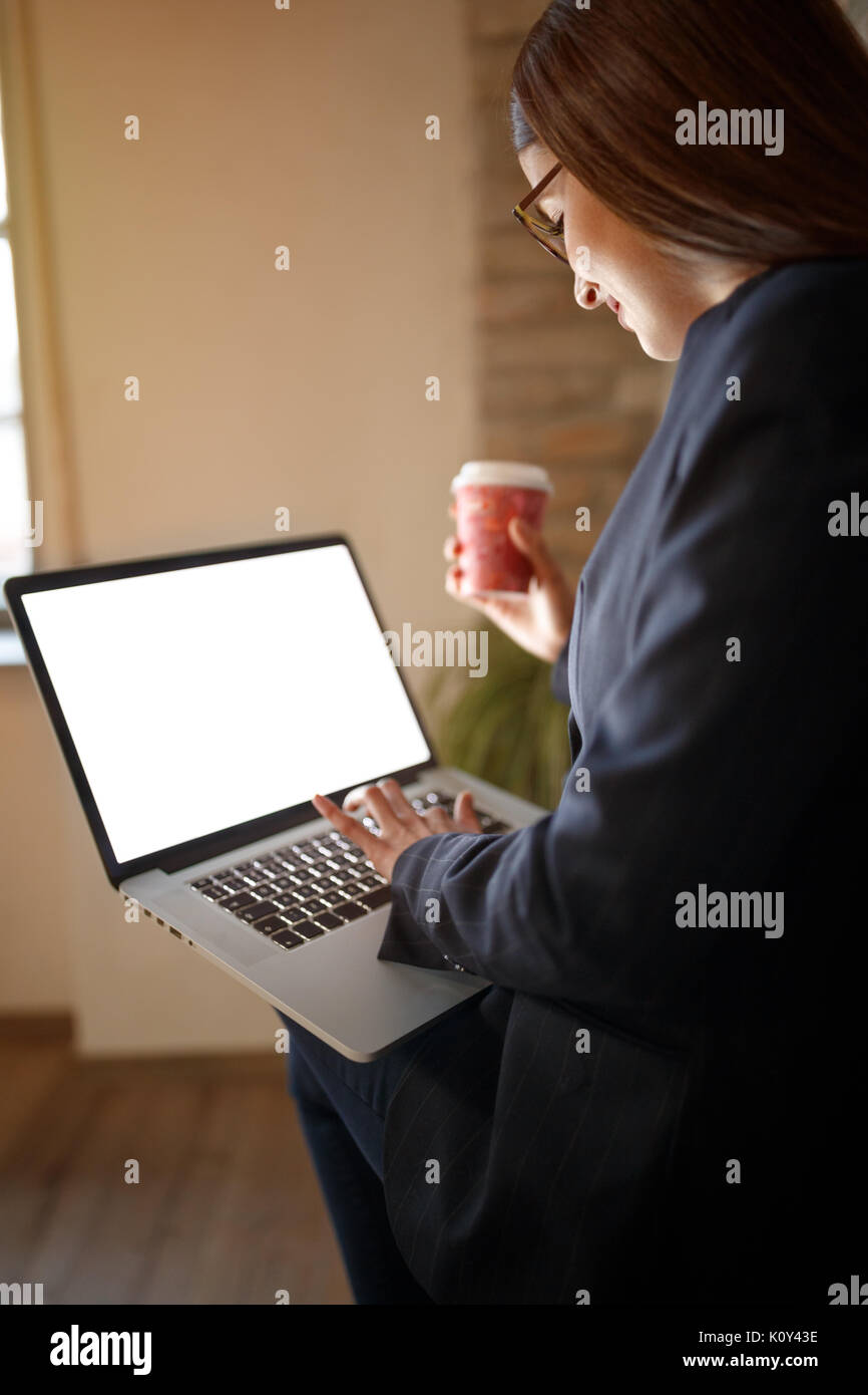 Moderno e giovane femmina funziona su computer portatile in ufficio Foto Stock