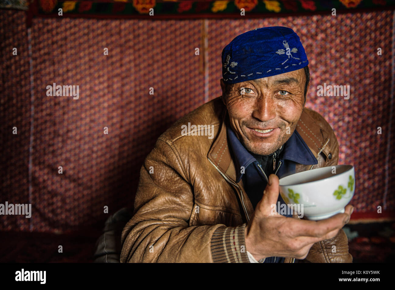 Un verde-eyed Uighur uomo in appoggio e a pranzo a mezzogiorno in remoto di Xinjiang Foto Stock