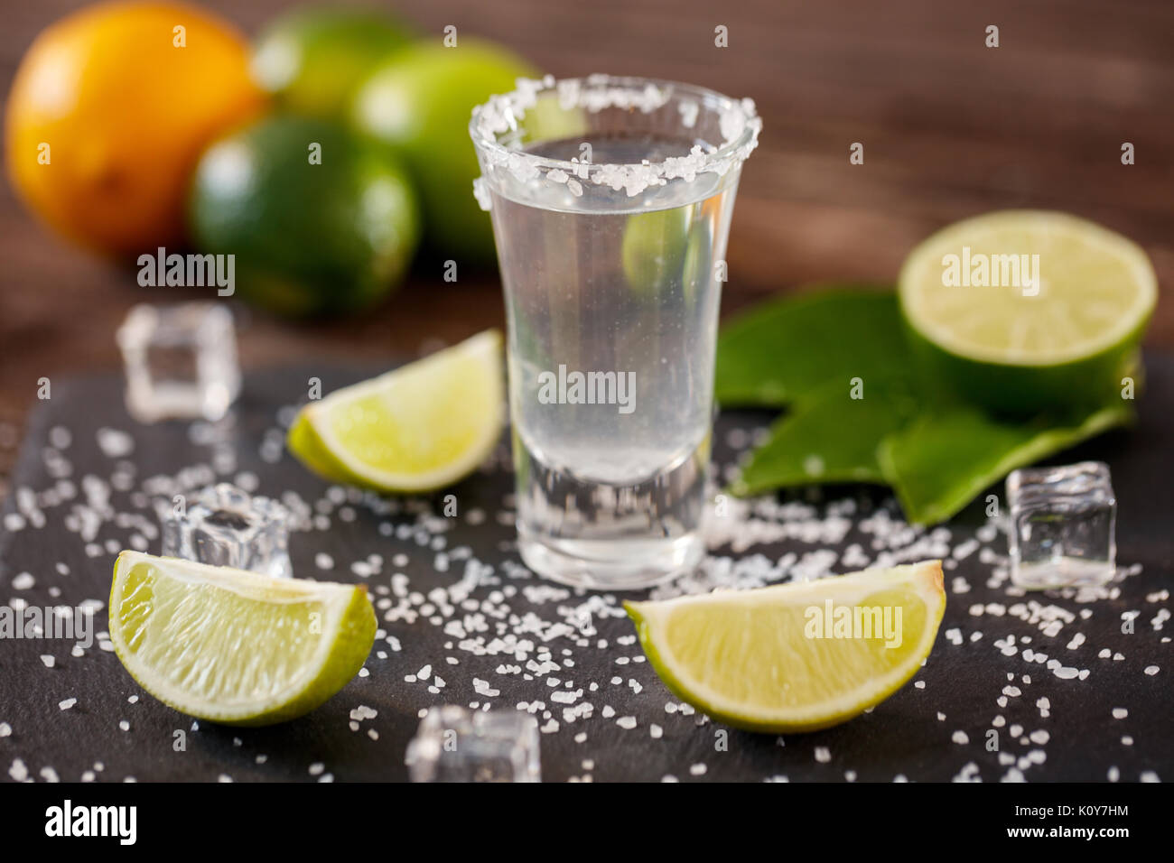 Tequila messicana in breve i bicchieri con sale, fettine di lime e il ghiaccio sul tavolo di legno Foto Stock