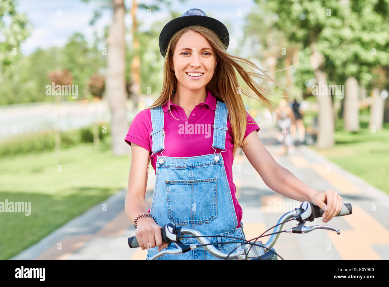 Bella giovane donna con la sua bicicletta al parco Foto Stock