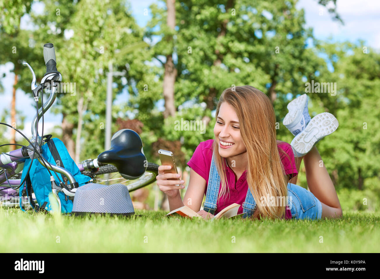 Giovane donna con il suo smart phone al parco Foto Stock