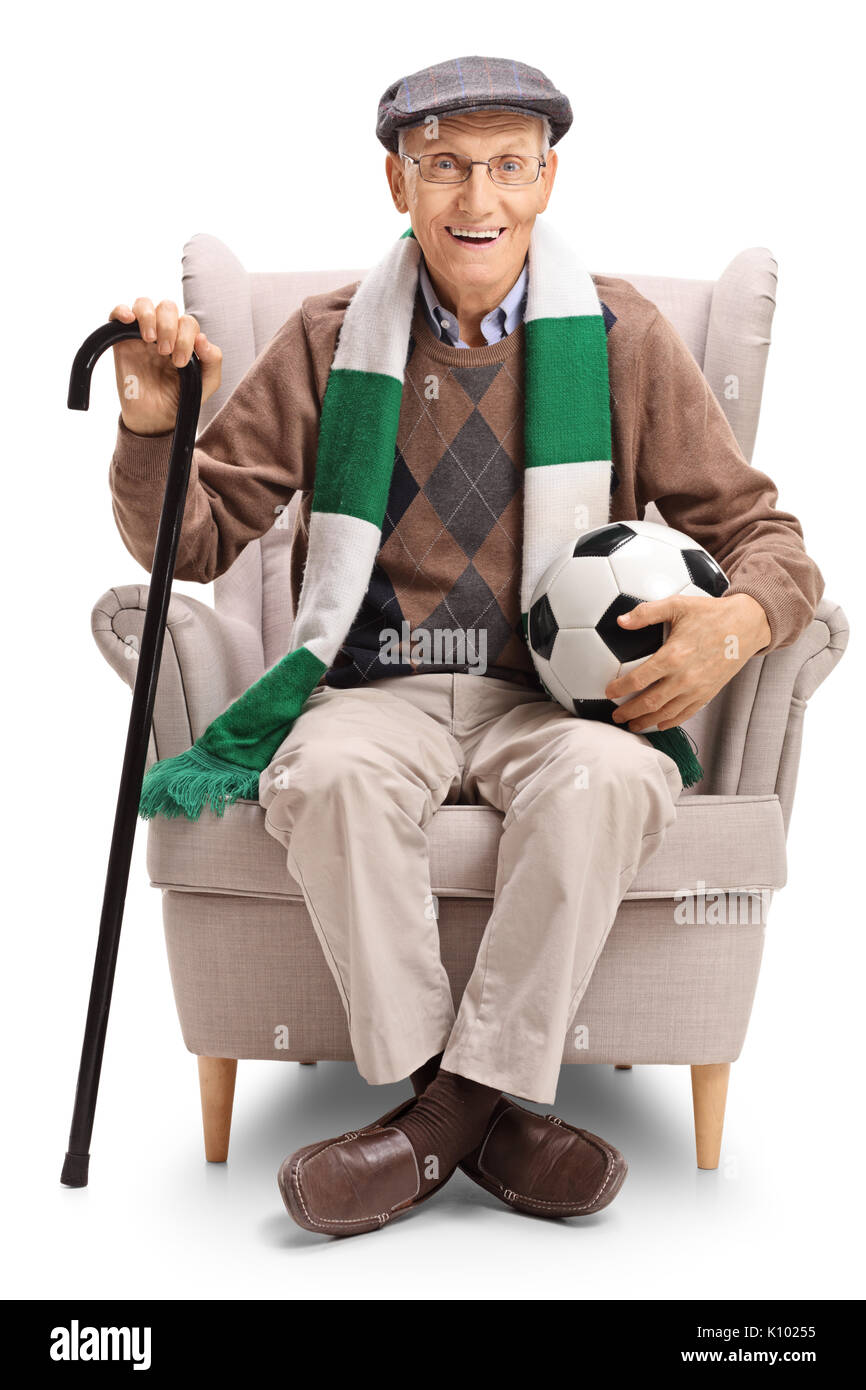 Anziani tifoso di calcio con un campo di calcio e un foulard seduto in poltrona isolati su sfondo bianco Foto Stock