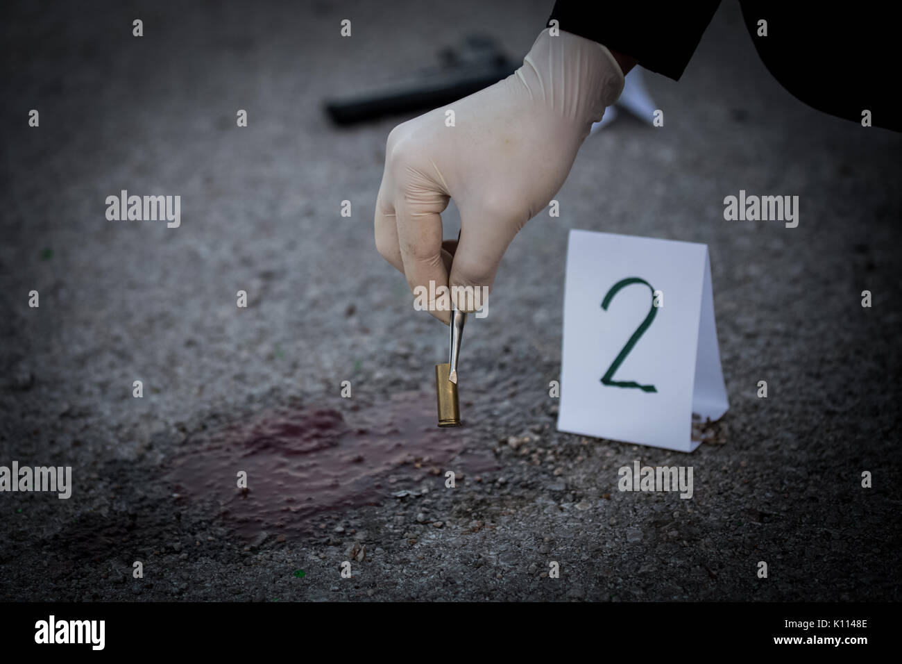 La scena del crimine, omicidio, inchiesta, manicotti scatti servire come prova, l'inchiesta è fatto, l'esperto prende la capsula forcipi e poste in Foto Stock