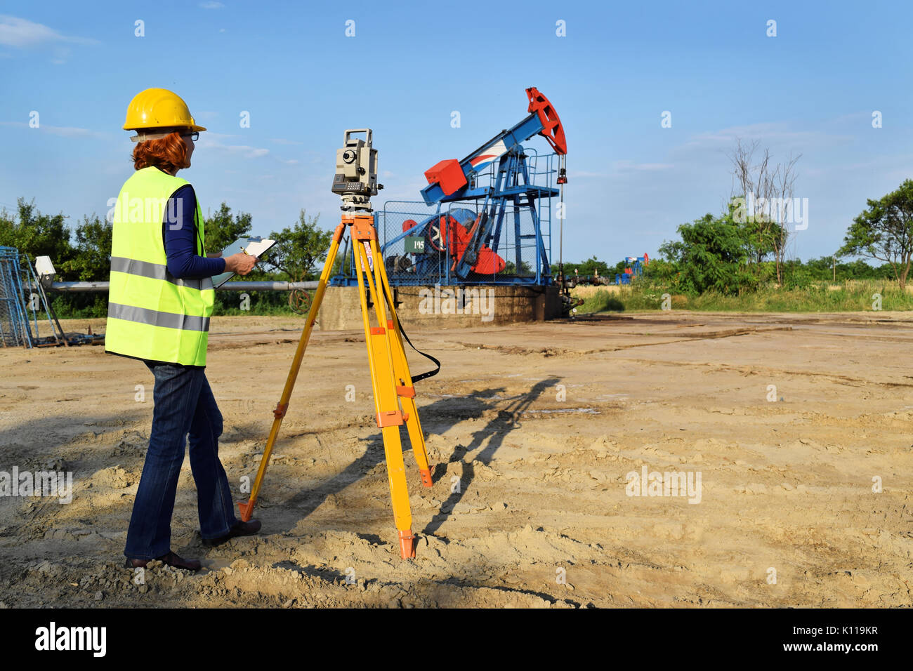 Geometra al lavoro e olio greggio pompa in background Foto Stock