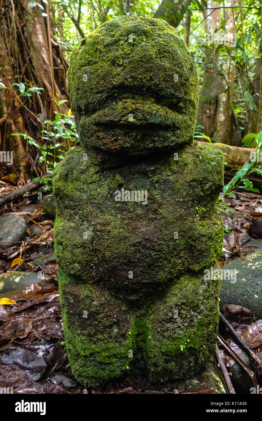Tiki statua sull'escursione a Vaipo waterfal la cascata più grande in Polinesia al di fuori della Nuova Zelanda. Sull'isola di Nuku Hiva delle Marquesas Foto Stock