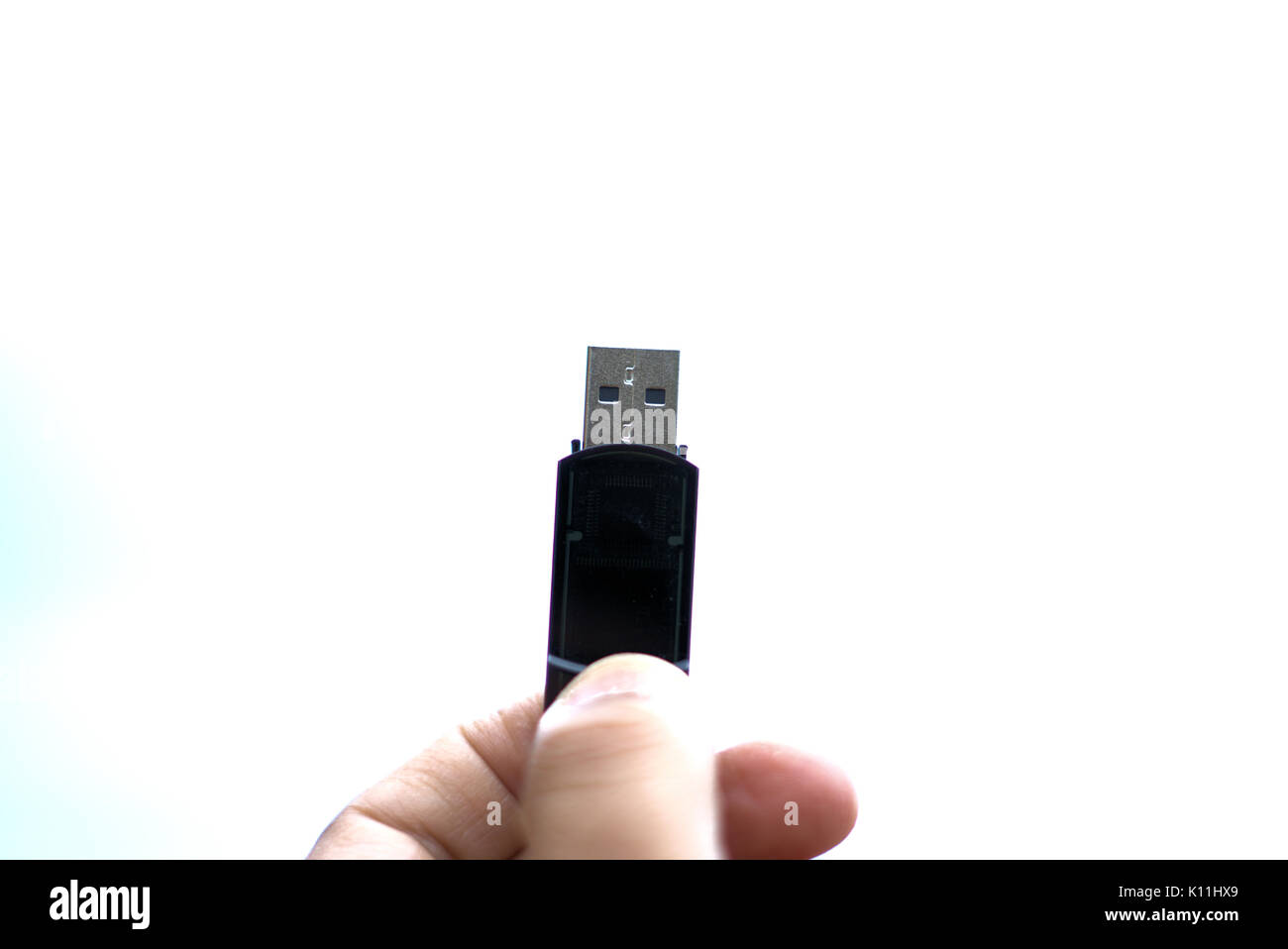 Pen Drive USB stick in mano o unità di memoria in mano nel vicino a sfondo bianco. Chiamato anche unità flash o pennetta USB o una Memory Stick™ per la memorizzazione dei dati Foto Stock